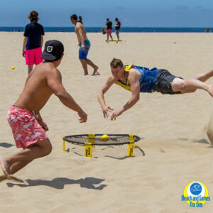 people playing spikeball on the beach