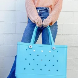 woman holding bogg bag for scale
