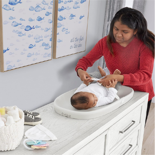 woman using Evolur Eva changing pad with infant